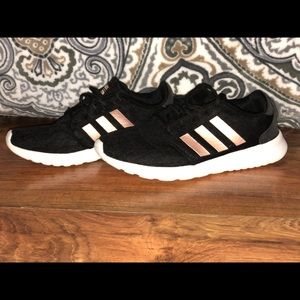 Black and rose gold adidas foams.